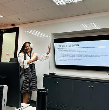 A speaker presenting to a room beside a session recap slide.